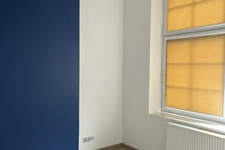 Wykończone wnętrze z granatową ścianą i oknem po remoncie w Chojnicach